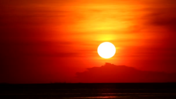 naplemente a vörös narancssárga égen vissza a világos narancssárga felhő és a sötét tenger idő szünet - Felvétel, videó