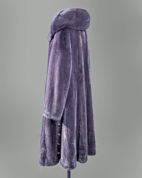 Nerzmantel blasslila mit ausgestelltem Saum und Knöpfen für den Ladenkatalog - Foto, Bild