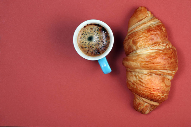 croissant and cup of coffee. croissant and coffee on a bright colorful background. top view. copy spaces - Foto, afbeelding
