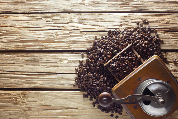 Кофейная мельница с кофейными зёрнами на деревянном фоне
 - Фото, изображение