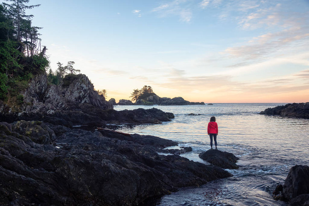 Wild Pacifc Trail, Ucluelet, Vancouver Island, BC, Canada. Girl Enjoyin the Beautiful View of the Rocky Ocean Coast during a colorful and vibrant morning sunrise. - Photo, image