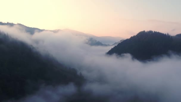 Vliegen door de wolken boven de bergtoppen. Hoge pieken prachtige ochtend zonsopgang natuurlijk landschap - Video