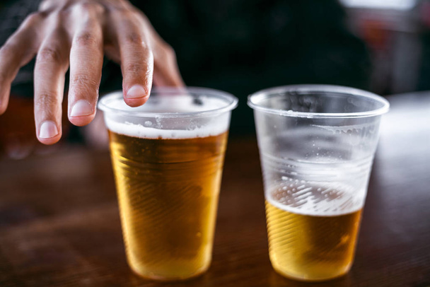 Два пластиковых стакана с пивом стоят бок о бок
 - Фото, изображение