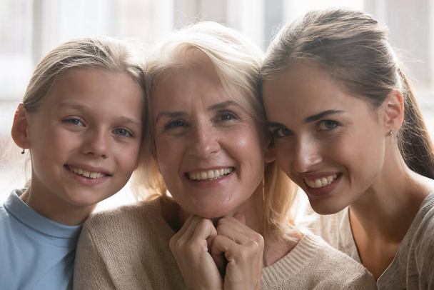Porträt von drei Generationen von Frauen, die zu Hause posieren - Foto, Bild