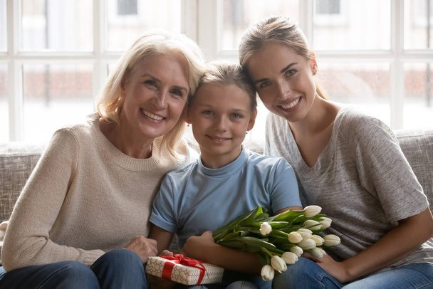Portrait of three generations of women posing with presents - Photo, Image