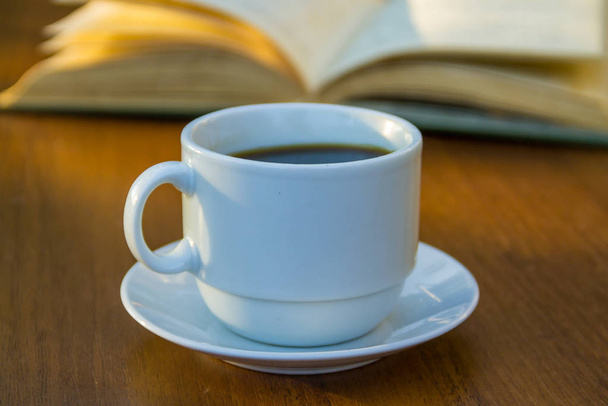 Egy csésze kávé és könyv a fa asztalra - Fotó, kép