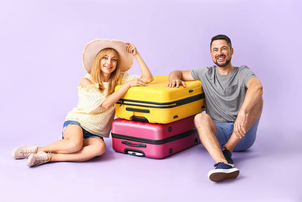 Пара с чемоданами на цветном фоне
 - Фото, изображение