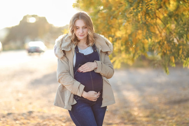 Beautiful young woman outdoor happy and pregnant - Фото, изображение