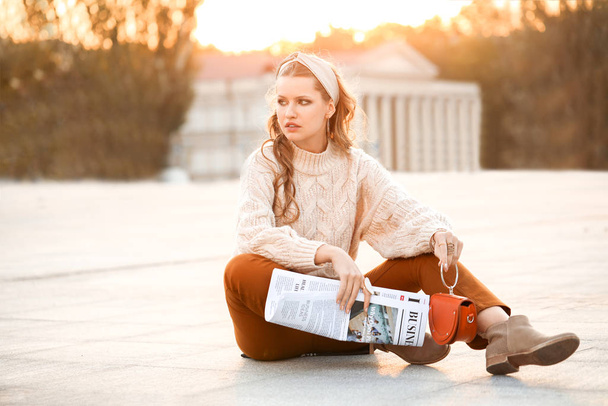 Μοντέρνα νεαρή γυναίκα με εφημερίδα σε εξωτερικούς χώρους - Φωτογραφία, εικόνα