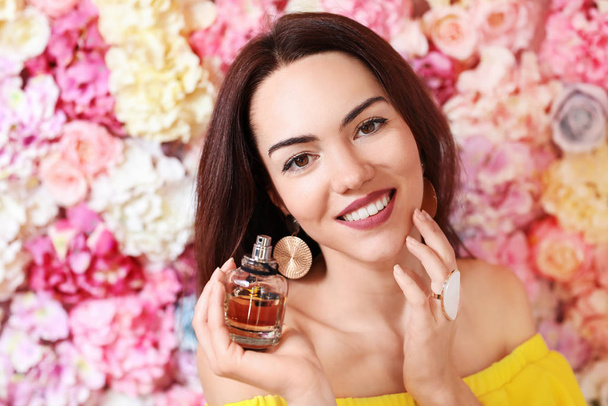Portrait of beautiful young woman with floral perfume - 写真・画像