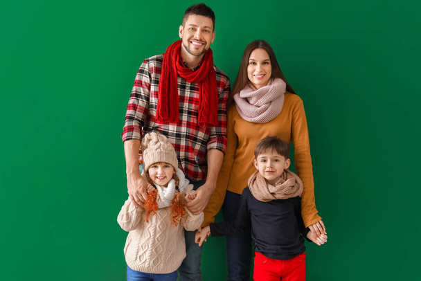 Ευτυχισμένη οικογένεια το χειμώνα ρούχα στο φόντο χρώμα - Φωτογραφία, εικόνα