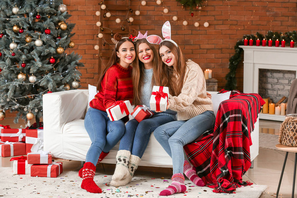 Belles jeunes femmes avec des cadeaux célébrant Noël à la maison
 - Photo, image