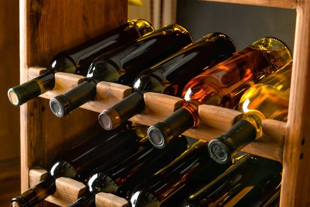 Drewniany uchwyt z butelkami wina w piwnicy - Zdjęcie, obraz