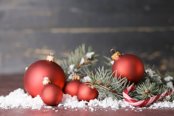 Mooie kerstballen met sneeuw en sparren takken op tafel - Foto, afbeelding