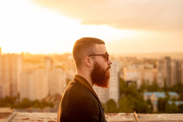 Stylish bearded male on rooftop in evening - Φωτογραφία, εικόνα