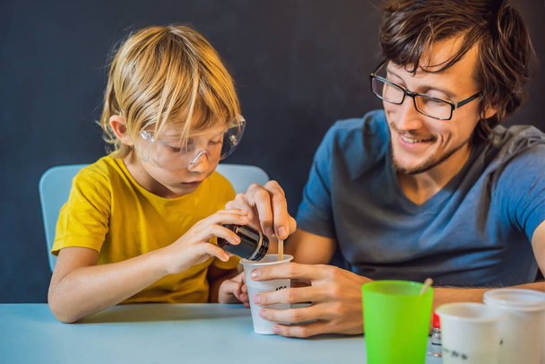 Father and son conduct chemical experiments at home. Home made slime - Foto, afbeelding