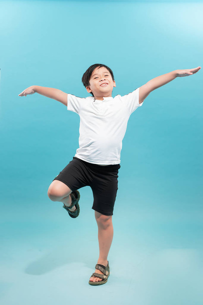 fröhlicher kleiner Junge, der Spaß beim Springen hat und mit den Armen wedelt. isoliert auf weißem Hintergrund. - Foto, Bild