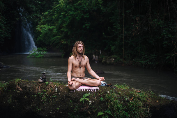 Yoga-Praxis und Meditation in der Natur. Mann übt in Flussnähe - Foto, Bild