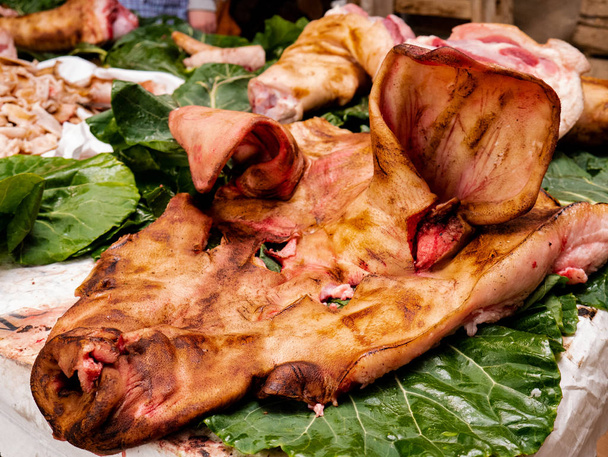 Natureza morta da visão explodida de um porco com uma grande máscara de porco e carne de sobra em folhas de repolho
 - Foto, Imagem