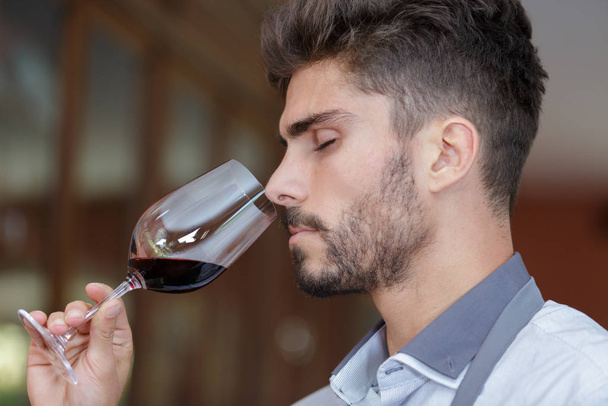 a sommelier is tasting wine - Foto, afbeelding