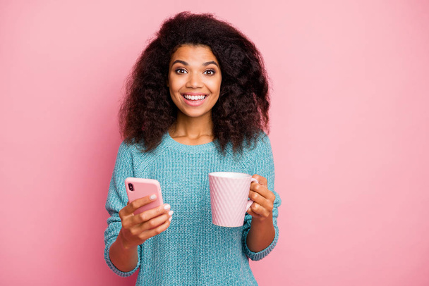 Close-up portrait of her she nice attractive lovely pretty cheerful cheery wavy-haired girl using digital device drinking cacao isolated over pink pastel color background - Foto, imagen