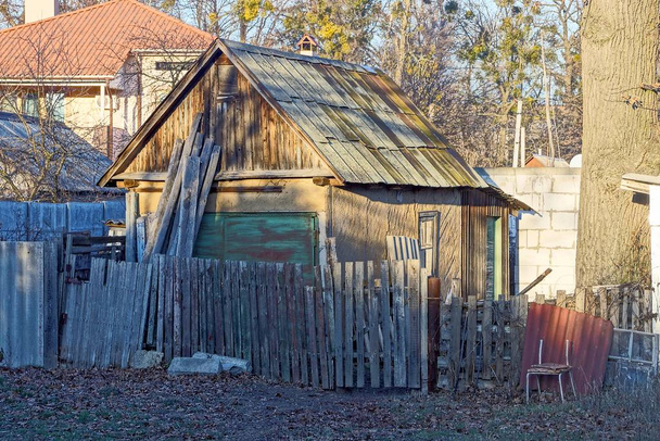 通りの灰色の木の柵の後ろにある古い田舎の納屋 - 写真・画像