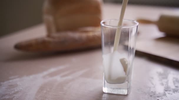 Pour milk into a glass in the kitchen - Felvétel, videó