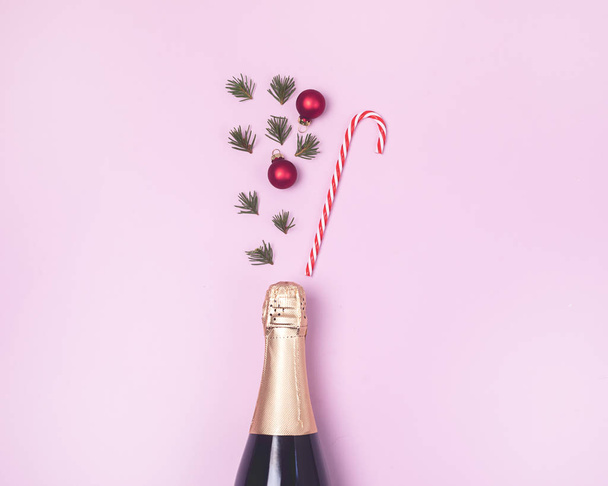 Champagne Bottle on Pink Background Minimal Party Holiday Concept Festive Top View Christmas New Year Decorations - Foto, afbeelding