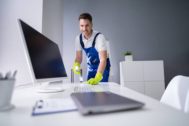 Portrait Of Happy Young Maid Cleaning Glass Table In Office - Foto, Bild