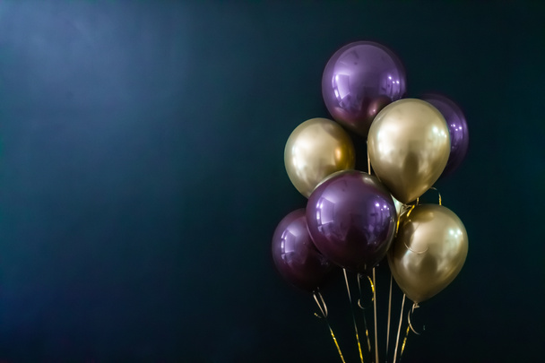 Набір золотих і фіолетових кульок на темному тлі. Концепція свята, листівка
 - Фото, зображення