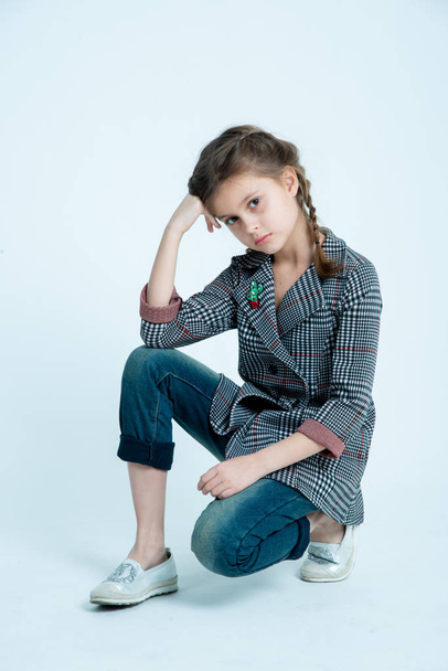 sweet and positive girl kid at photo studio on gray background - Фото, зображення