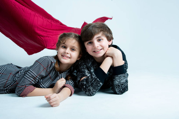 cute kids boy and girl posing in studio on gray background - Photo, image