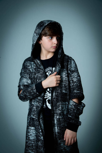 kid boy posing in photo studio on dark background - Fotó, kép