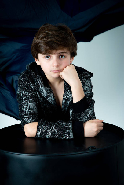 close up portrait kid boy sitting with black barrel  - Φωτογραφία, εικόνα