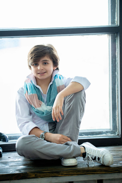 boy kid sitting and smiling on windowsill lifestyle mood - Fotografie, Obrázek