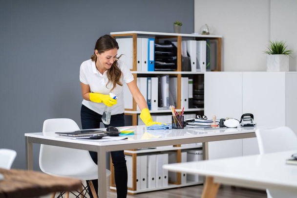 Young Worker Cleaning Desk With Rag In Office - Photo, Image