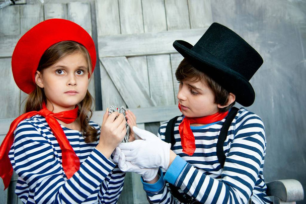 beautiful friends kids in striped sweaters playing on wooden sofa - Foto, Imagen