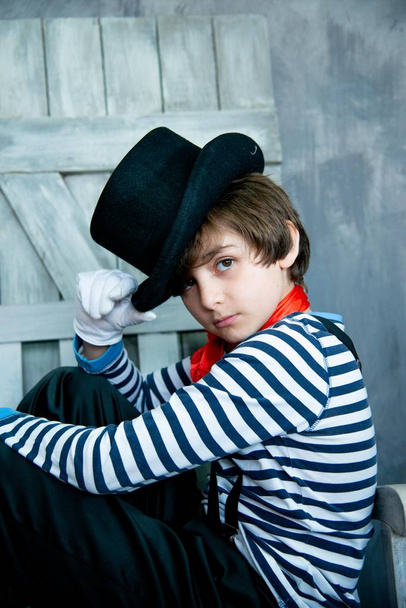 boy with expressive look in striped sweater and black hat in mime costume  - Valokuva, kuva