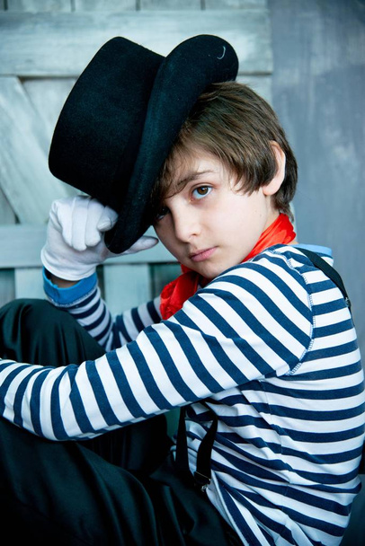 fiú kifejező pillantást csíkos pulóver és fekete kalap pantomim jelmezben  - Fotó, kép