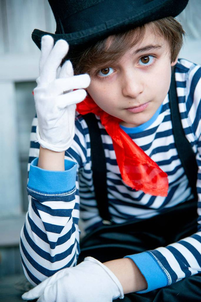 boy portrait in mime costume in vest and black hat and red shawl - Valokuva, kuva