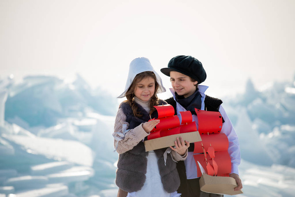 sweet girl and boy playing with wooden ship toys on ice background  - Fotó, kép
