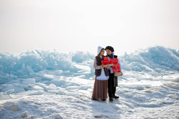 children holding wooden sailboats toys on winter frozen coast  - Zdjęcie, obraz
