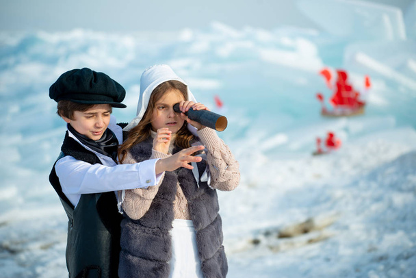 winter children playing pirates looking spyglass on iceberg  - Zdjęcie, obraz