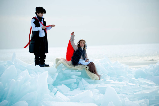 kids in themed costumes on iceberg on winter landscape - Photo, Image