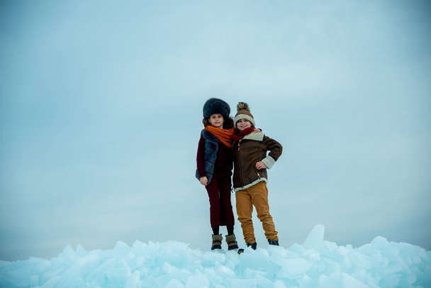 funny boy and girl standing on polar winter ice  - Фото, зображення