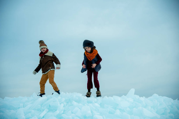 kids standing on winter ice on snow background - Fotoğraf, Görsel
