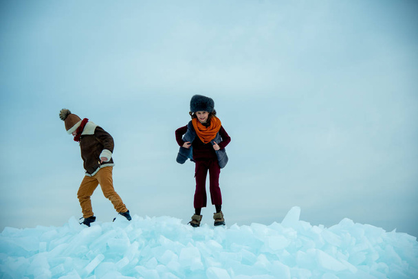 children playing on ice on winter background - Foto, Bild