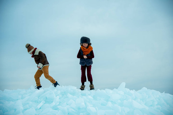 children playing on ice on winter background - Fotoğraf, Görsel