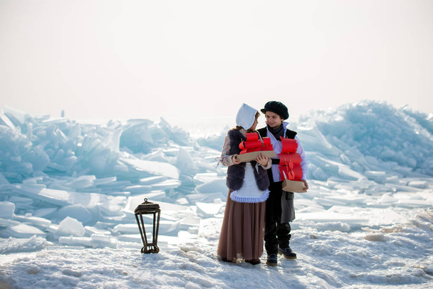 children standing on iceberg with wooden ship toys on winter background - Fotó, kép