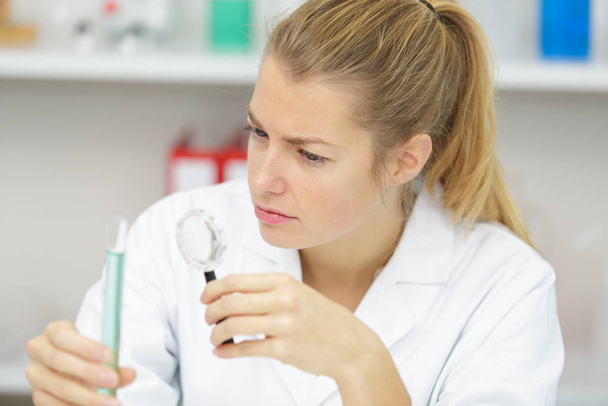 woman doctor holds a test tube in lab - Φωτογραφία, εικόνα